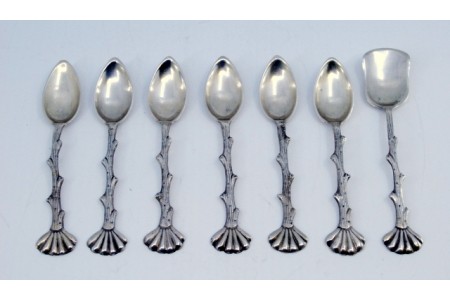  Conjunto de seis colheres de café em prata e pá de açúcar com relevos nos cabos em forma de troncos.